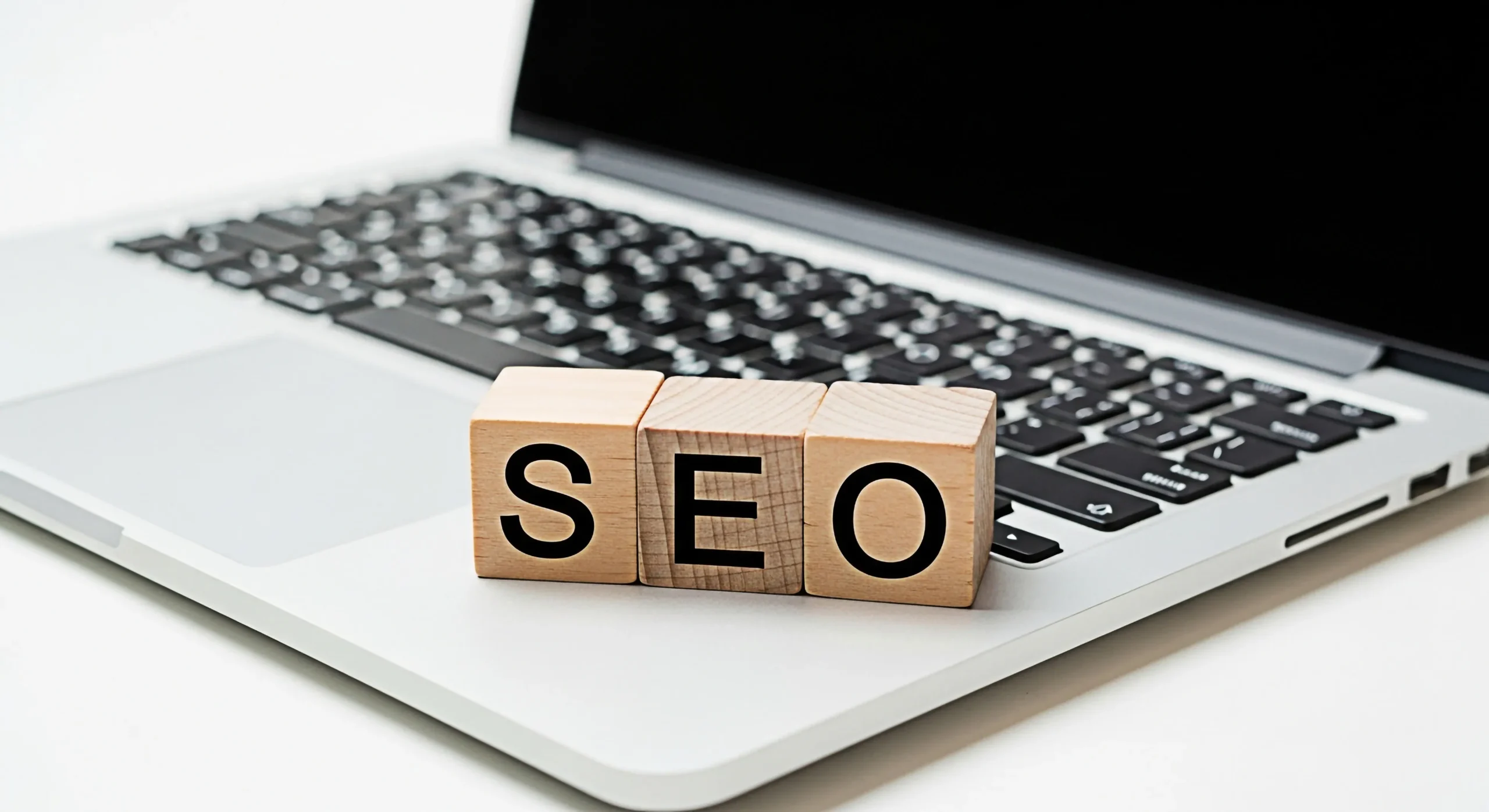 SEO Schriftzug auf Laptop als Symbol für professionelle Suchmaschinenoptimierung